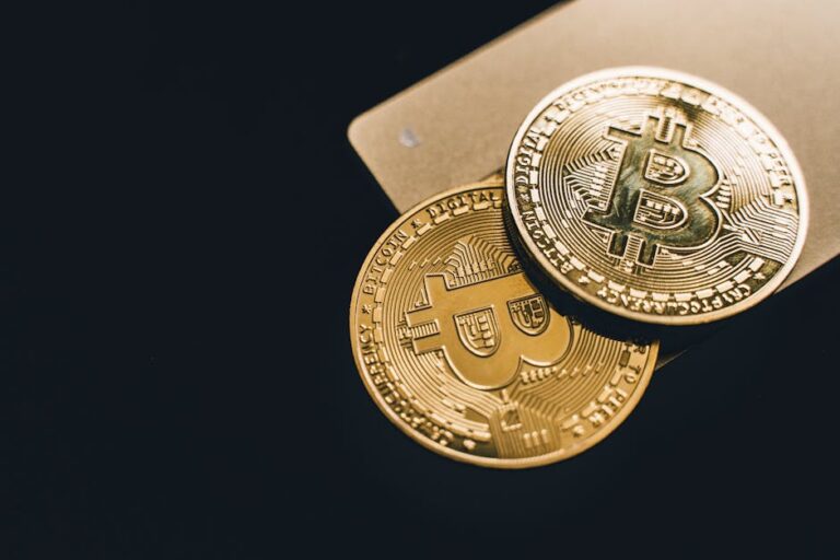Close-up image of two gold bitcoin coins on a dark background, symbolizing cryptocurrency.
